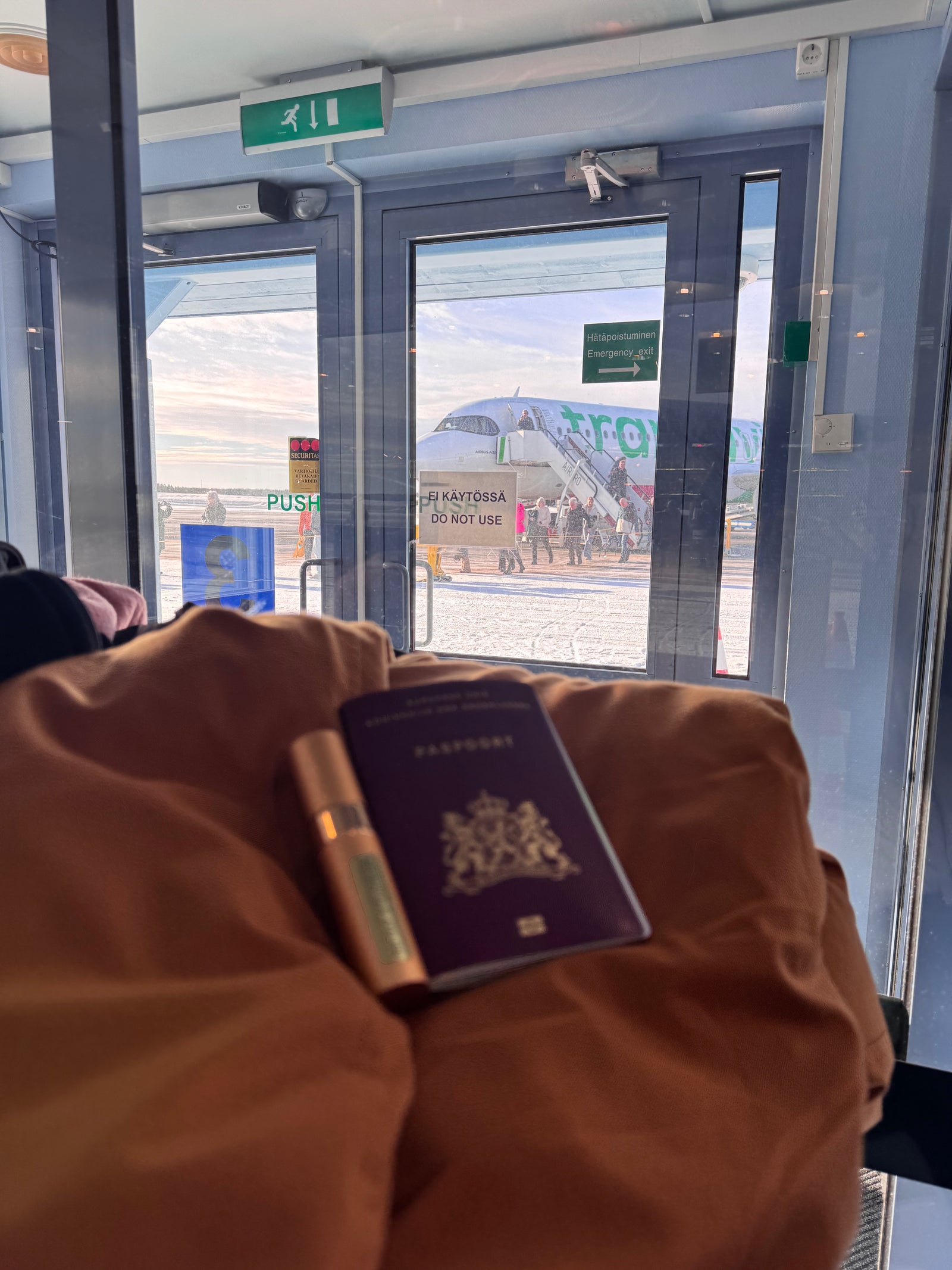 Flacon van 10 ml met een paspoort op schoot op de luchthaven